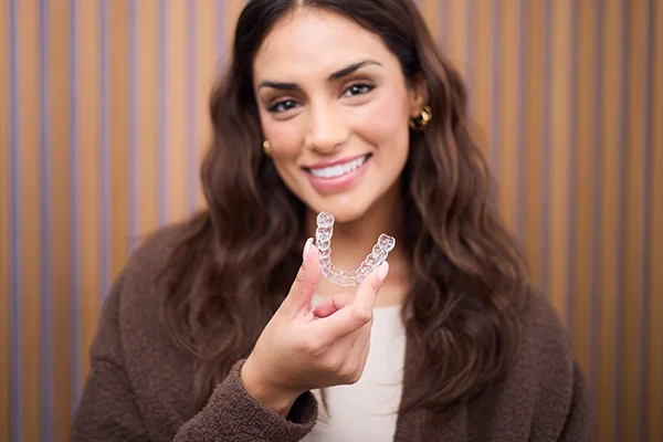 A woman holding up her spark aligners