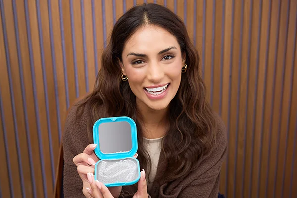 A woman holding an open Spark Aligners case